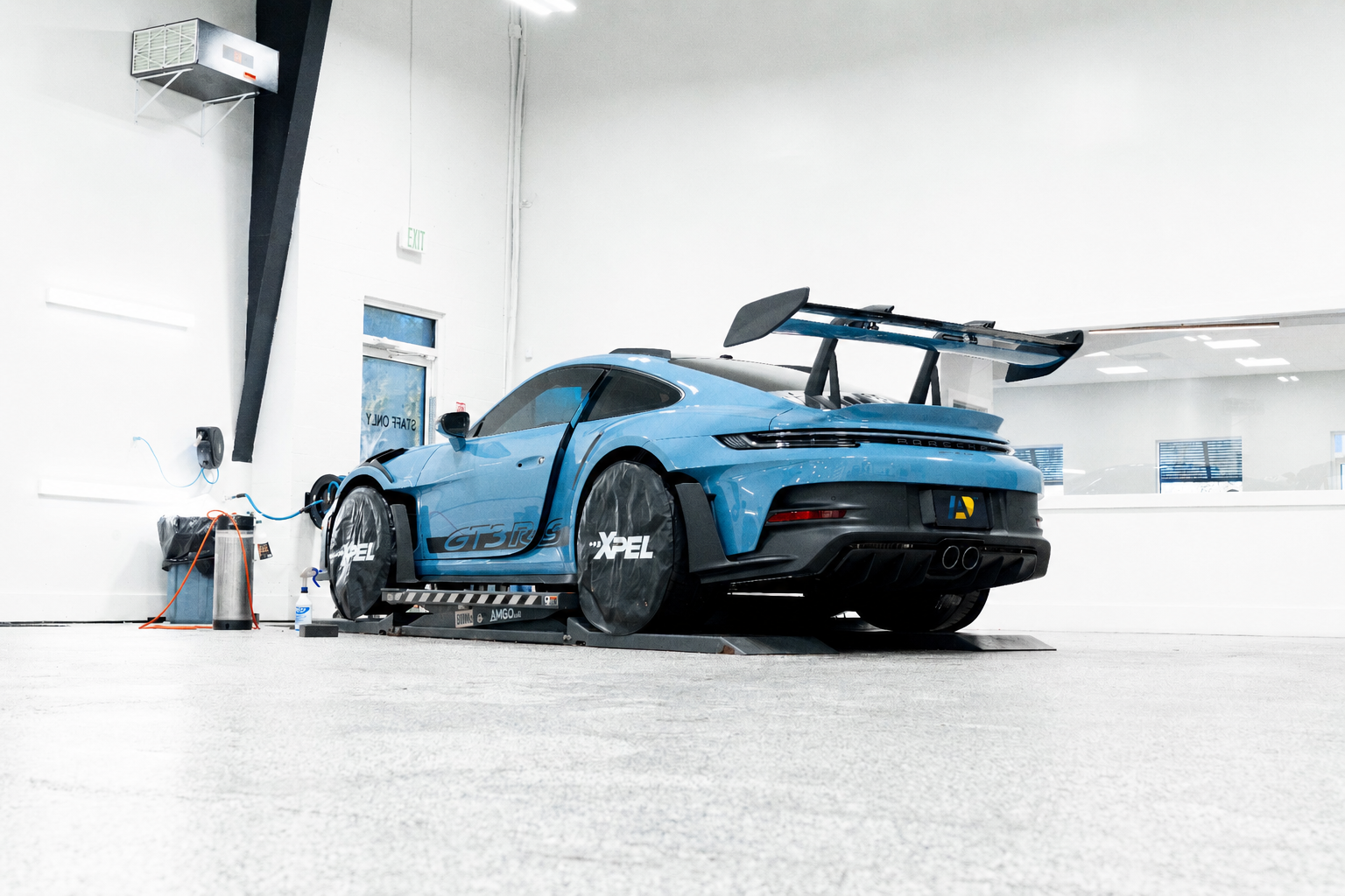 White Porsche 911 GT3 being detailed inside the Detailers of Ann Arbor shop with a Ferrari visible in the background